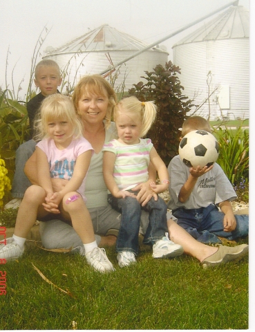 Pam (Birdsall) Linn on her farm with four of her five grandchildren.  Jarrett Miller, Jadyn Miller, Pam,  Ella Toot, and Jed Miller (behind soccer ball.)